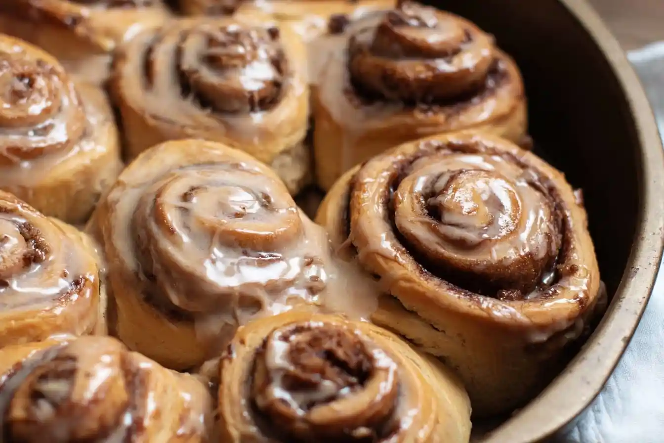 Freshly baked {{ $('Fetch Recipe Data').first().json["Main Keyword"] }} in a round pan, topped with sweet melting icing.