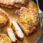 Sliced golden {{ $('Fetch Recipe Data').first().json["Main Keyword"] }} in a pan showing a juicy interior, garnished with thyme.