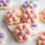 Pastel {{ $('Fetch Recipe Data').first().json["Main Keyword"] }} with piped pink and purple frosting petals.